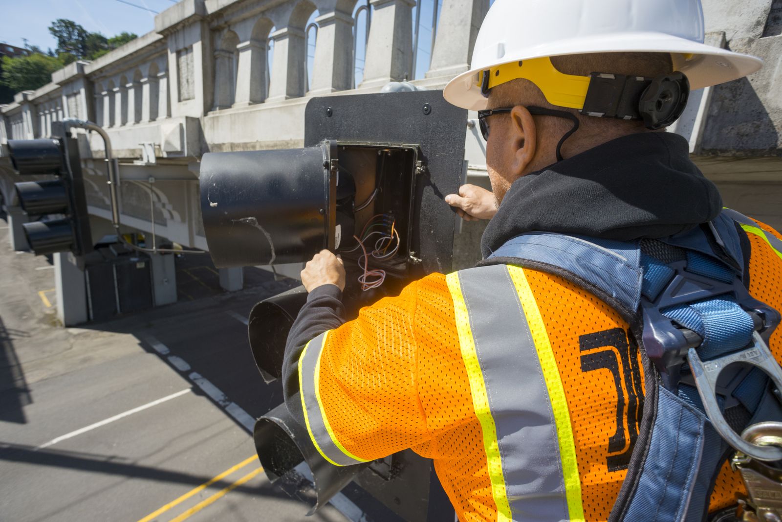 Technician working inside a roadside traffic signal controller cabinet