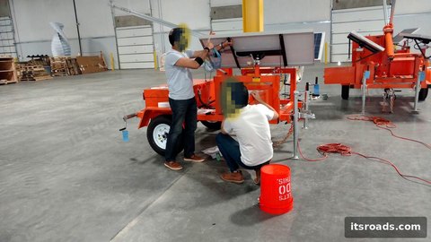 Solar-powered trailer in a warehouse with two technicians