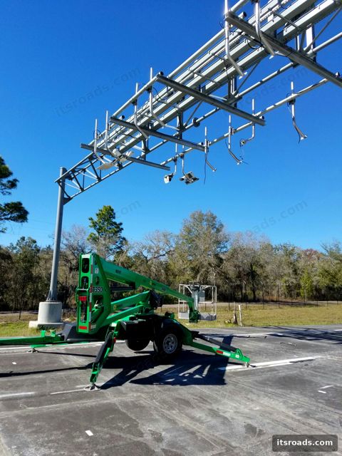 Toll gantry with readers and boom lift under blue sky