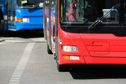 City transit bus at a stop with pedestrians nearby