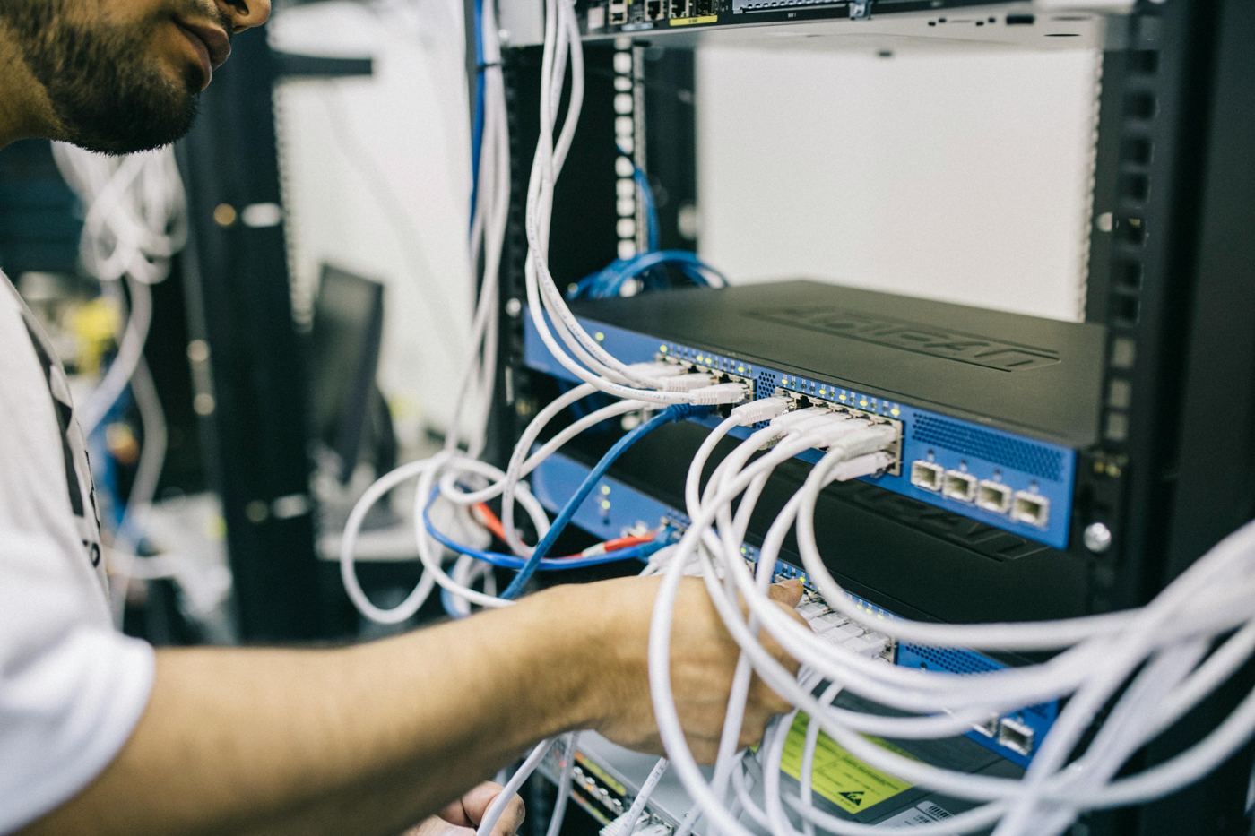 Engineer working on network rack equipment