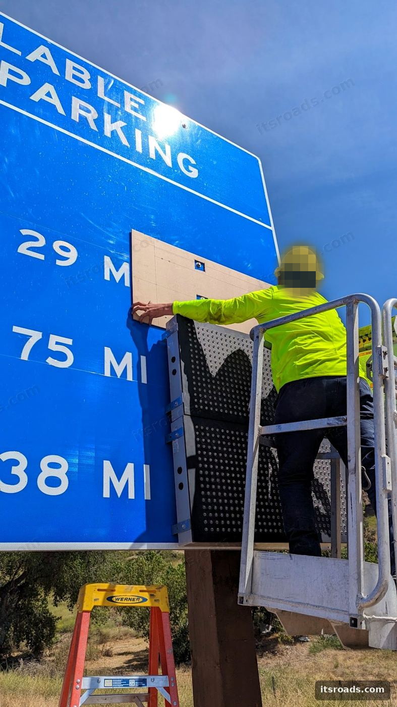 Crew installing a Streetline TPAS availability sign from a bucket truck